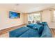 Spacious living room featuring a wall-mounted TV, sliding doors to backyard, and a large blue sectional at 1650 Springdale Dr, Holiday, FL 34691