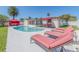 Relax by the pool with lounge chairs, an outdoor dining area, and a cozy cabana for the ultimate relaxation at 1650 Springdale Dr, Holiday, FL 34691