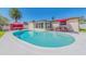An inviting backyard with a sparkling pool, covered lanai, and lush landscaping at 1650 Springdale Dr, Holiday, FL 34691