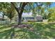 Expansive backyard with lush green lawn, mature trees, patio, and white picket fence at 1806 Chickasaw Trl, Valrico, FL 33596