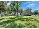 A backyard featuring lush green grass, mature shade trees, and a small garage or shed at 1806 Chickasaw Trl, Valrico, FL 33596