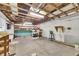 Unfinished basement showcasing exposed wood beams, concrete floor, and shelving units for storage at 1806 Chickasaw Trl, Valrico, FL 33596