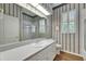 Bathroom with a large mirror, patterned wallpaper and shower at 1806 Chickasaw Trl, Valrico, FL 33596