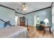 Large bedroom boasting hardwood floors, plenty of natural light, a four-poster bed, and a seating area at 1806 Chickasaw Trl, Valrico, FL 33596