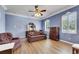 This is a roomy bedroom with cool blue walls, matching furniture, hardwood floors and bright natural light at 1806 Chickasaw Trl, Valrico, FL 33596