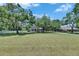 Serene view of a home set back on a large, well-maintained grassy lot at 1806 Chickasaw Trl, Valrico, FL 33596