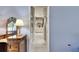 Open hallway leading into a bathroom that features tile flooring, a vanity with a lamp and a sink at 1806 Chickasaw Trl, Valrico, FL 33596