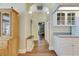Bright hallway featuring wood-look floors, an arched doorway, and built-in storage cabinets and display shelves at 1806 Chickasaw Trl, Valrico, FL 33596