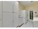 Functional laundry room featuring ample white storage cabinets, countertop, and a side-by-side washer and dryer at 1806 Chickasaw Trl, Valrico, FL 33596