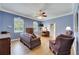 A comfortable sitting room with lots of space, bright windows, and a ceiling fan at 1806 Chickasaw Trl, Valrico, FL 33596