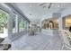 Spacious sunroom with large windows offering panoramic views, complemented by wicker dining sets and tiled flooring at 1806 Chickasaw Trl, Valrico, FL 33596