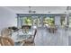 Spacious sunroom featuring tiled floor, wicker seating, and large windows overlooking the backyard and white picket fence at 1806 Chickasaw Trl, Valrico, FL 33596