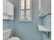 A separate toilet room with storage cabinets, a window, and a wall mounted fold down ironing board at 1806 Chickasaw Trl, Valrico, FL 33596
