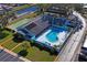 Aerial view featuring a community pool, shuffleboard court, and well-maintained landscaping at 200 Portree Dr, Dunedin, FL 34698