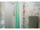 Bathroom with a white tiled shower, green shower curtain, and bamboo-patterned wallpaper at 200 Portree Dr, Dunedin, FL 34698