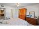 Bright bedroom with a ceiling fan, louvred door, and dresser with mirror at 200 Portree Dr, Dunedin, FL 34698