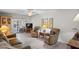 Living room area with hardwood floors, a comfortable seating arrangement, and sliding glass doors at 200 Portree Dr, Dunedin, FL 34698