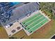 Aerial view of a shuffleboard court adjacent to a building with patio seating and green landscape at 200 Portree Dr, Dunedin, FL 34698