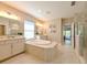 Elegant bathroom featuring a soaking tub, double vanities, and a separate glass-enclosed shower at 21794 Pristine Lake Blvd, Land O Lakes, FL 34637