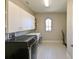 Modern laundry room with overhead cabinets and a front-loading washer and dryer at 21794 Pristine Lake Blvd, Land O Lakes, FL 34637