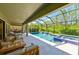 Amazing covered patio with a screened in pool and spa and comfortable seating with lush green landscape views at 21794 Pristine Lake Blvd, Land O Lakes, FL 34637
