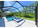 Aerial view of the screened in pool and spa with lush green landscape and trees beyond at 21794 Pristine Lake Blvd, Land O Lakes, FL 34637