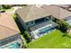 Aerial view of screened-in pool and spa with a spacious, green backyard and view of the home's rear exterior at 21794 Pristine Lake Blvd, Land O Lakes, FL 34637
