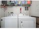 Laundry room with white washer and dryer, shelving, and a fire extinguisher at 2690 Coral Landings Blvd # 112, Palm Harbor, FL 34684