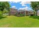 Spacious backyard features a screened lanai and lush green lawn, perfect for outdoor entertaining at 27054 Fordham Dr, Wesley Chapel, FL 33543