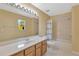 Cozy bathroom with a combination tub and shower, marble vanity top, and a large mirror at 27054 Fordham Dr, Wesley Chapel, FL 33543