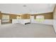 Spacious bonus room featuring neutral carpet, half wall accents, and two windows providing natural light at 27054 Fordham Dr, Wesley Chapel, FL 33543