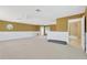 Large bonus room features neutral carpet, half wall accents, and an open door to a full bathroom at 27054 Fordham Dr, Wesley Chapel, FL 33543