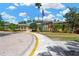 Charming clubhouse with a circular design, arched windows, and an American flag waving in front under a blue sky at 27054 Fordham Dr, Wesley Chapel, FL 33543