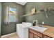 Functional laundry room features a utility sink, washer, dryer, and built-in shelving for ample storage at 27054 Fordham Dr, Wesley Chapel, FL 33543