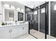 Modern bathroom boasts dual sinks, back-lit mirrors, and glass-enclosed shower with elegant tile work at 31966 Asbury Ave, Wesley Chapel, FL 33545