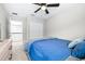 Carpeted bedroom with a large window, big closet, ceiling fan, and light blue bedding at 31966 Asbury Ave, Wesley Chapel, FL 33545