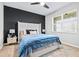 Comfortable bedroom boasts a ceiling fan, an accent wall, and a large window for ample natural light at 31966 Asbury Ave, Wesley Chapel, FL 33545