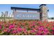 The Asbury community entrance sign is surrounded by vibrant pink flowers and lush greenery at 31966 Asbury Ave, Wesley Chapel, FL 33545
