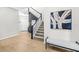 Inviting entryway with modern decor, a staircase, a stylish bench, and contemporary artwork at 31966 Asbury Ave, Wesley Chapel, FL 33545