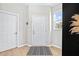 Bright entryway with light-colored walls, modern black-and-white rug, and ample natural light from a nearby window at 31966 Asbury Ave, Wesley Chapel, FL 33545