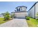 Charming two-story home features a two-car garage, manicured lawn, and lovely landscaping at 31966 Asbury Ave, Wesley Chapel, FL 33545
