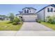 Charming two-story home features a two-car garage, manicured lawn, and lovely landscaping at 31966 Asbury Ave, Wesley Chapel, FL 33545