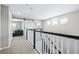 Upstairs hallway featuring a barn door, decorative railing, and plenty of natural light at 31966 Asbury Ave, Wesley Chapel, FL 33545