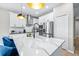 Bright kitchen featuring a modern island with a waterfall quartz countertop and stainless steel appliances at 31966 Asbury Ave, Wesley Chapel, FL 33545