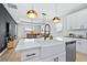 Open-concept kitchen featuring a large island with a white countertop and stainless steel appliances at 31966 Asbury Ave, Wesley Chapel, FL 33545