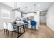 Open-concept kitchen features a center island, modern lighting, white cabinets, and stainless steel appliances at 31966 Asbury Ave, Wesley Chapel, FL 33545