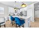 Bright kitchen with white cabinets, a quartz countertop island, and stainless steel appliances at 31966 Asbury Ave, Wesley Chapel, FL 33545