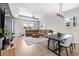 Open-concept room offers tray ceilings, wood floors, a large brown leather sectional, and bright natural light at 31966 Asbury Ave, Wesley Chapel, FL 33545