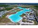 Wide aerial view showcasing a vibrant blue lagoon, resort-style amenities, and stylish residences in a Primary-planned community at 32046 Powderpuff Mimosa Dr, San Antonio, FL 33576