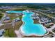 Elevated view of a community lagoon featuring crystal-clear water, modern homes, and ample recreational spaces at 32046 Powderpuff Mimosa Dr, San Antonio, FL 33576